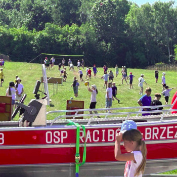 Zdjęcie ogólne placu imprezy. Uczestnicy chodzą po boisku