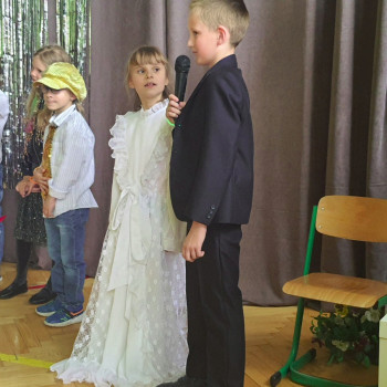 Chłopak ubrany w galowy garnitur i dziewczyna ubrana w białą suknię