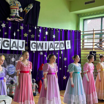 Uczennice ubrane w stroje stylizowane na historyczne, stojące w rzędzie na scenie podczas gali laureatów