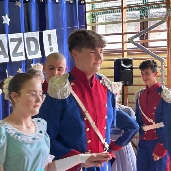 Uczniowie ubrani w stroje stylizowane na historyczne, występujący na scenie podczas gali