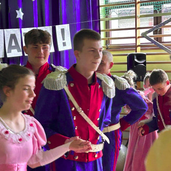 Uczniowie ubrani w stroje stylizowane na historyczne, występujący na scenie podczas gali laureatów