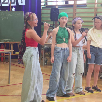 Czworka uczniow śpiewa piosenkę do mikrofonu