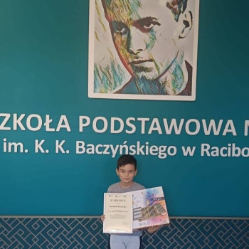 zwycięzca z dyplomem na tle nazwy szkoły