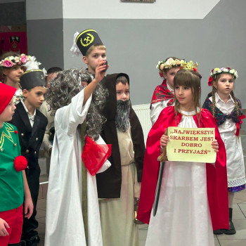 Dziewczynka trzymająca kartkę z napisem Najwiękrzym skarbem jest dobro i przyjaźń w przebraniu