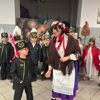 Chlopiec ubrany w strój górnika rozmawia z dziewczyną ubraną w strój ludowy