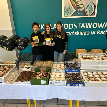 Zdjęcie trójki uczniów obsługujących stoisko